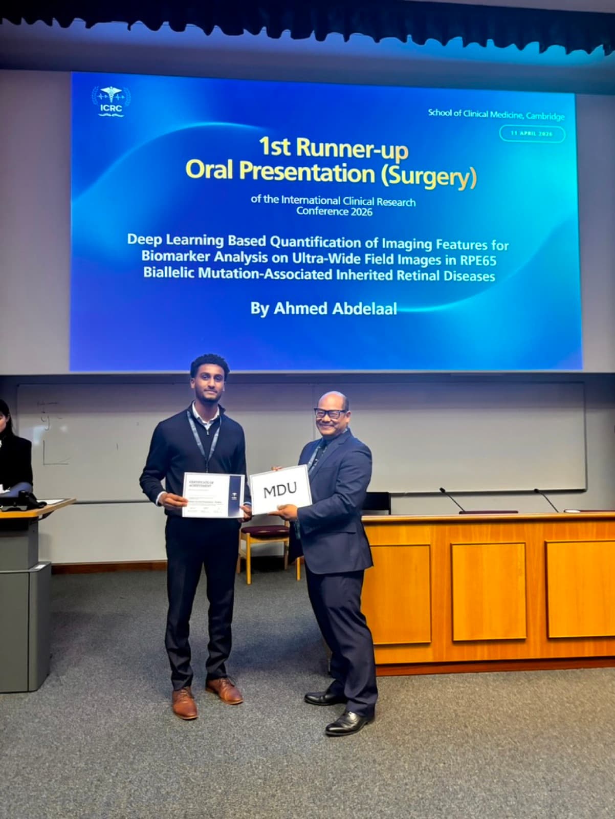 Ahmad Abdelaal receiving recognition at a Cambridge medical research event